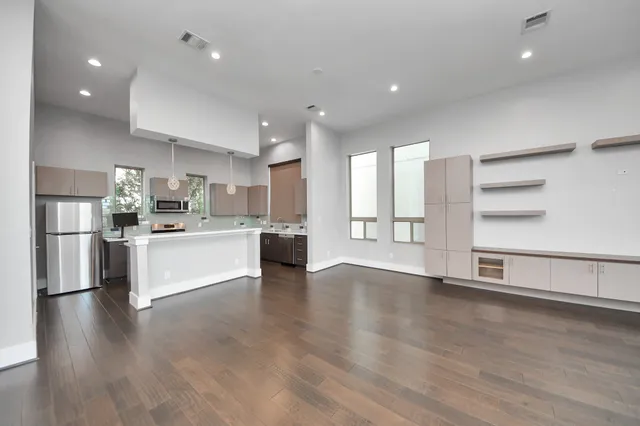 a view of kitchen with stainless steel appliances kitchen island large trees and wooden floors