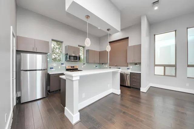 a kitchen with a refrigerator and a stove top oven