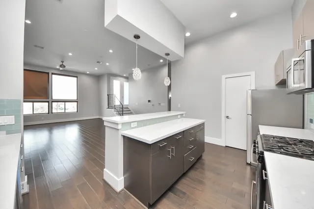 a kitchen with a stove and a wooden floor
