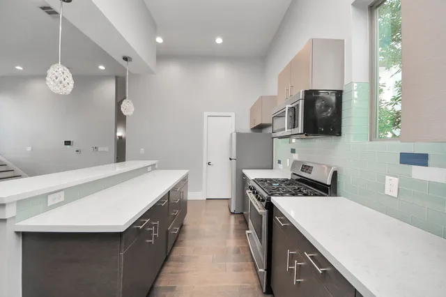 a kitchen with a sink a counter top space stainless steel appliances and a window