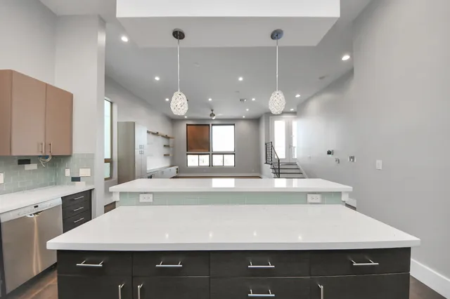 a room with kitchen island a sink and a stove with wooden floor
