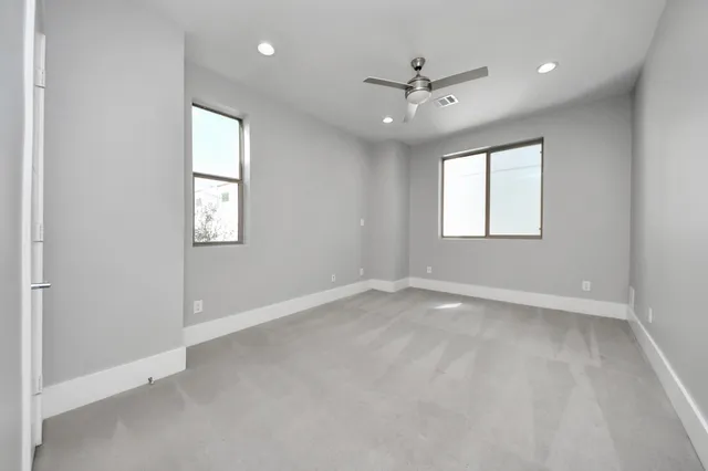 an empty room with windows and closet