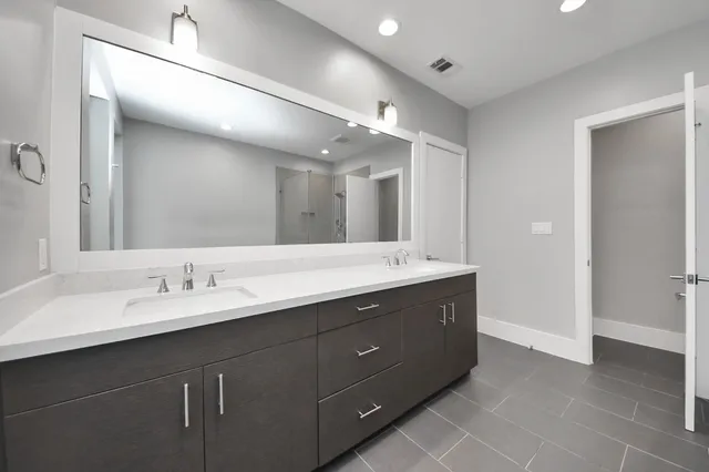 a bathroom with a double vanity sink and a mirror