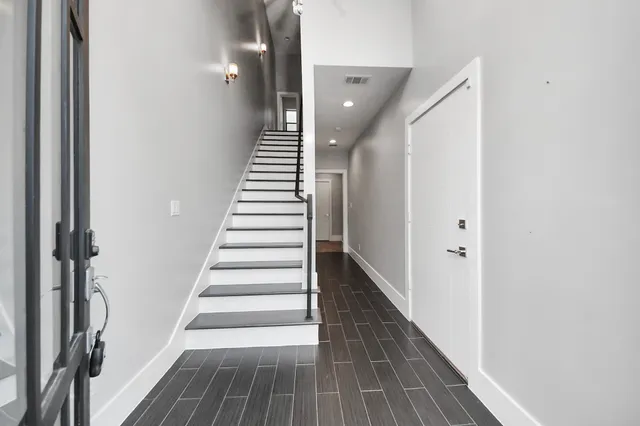 a view of a hallway with wooden floor and entryway