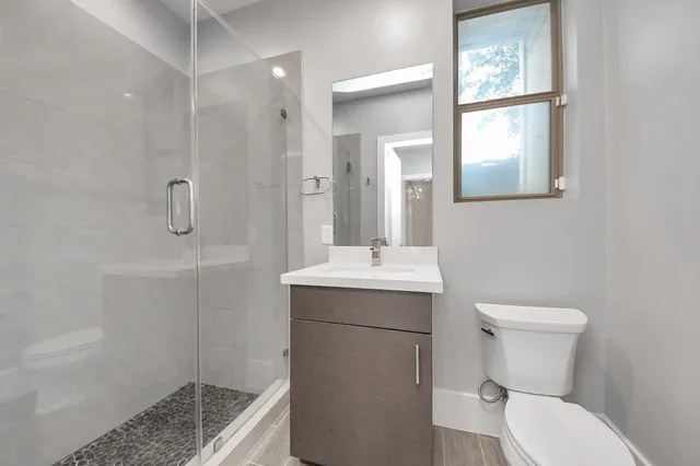 a bathroom with a sink a toilet and shower