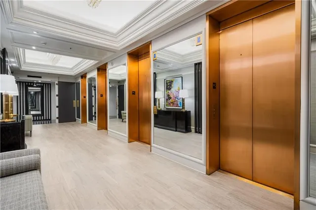 a view of a hallway with furniture and bathroom view