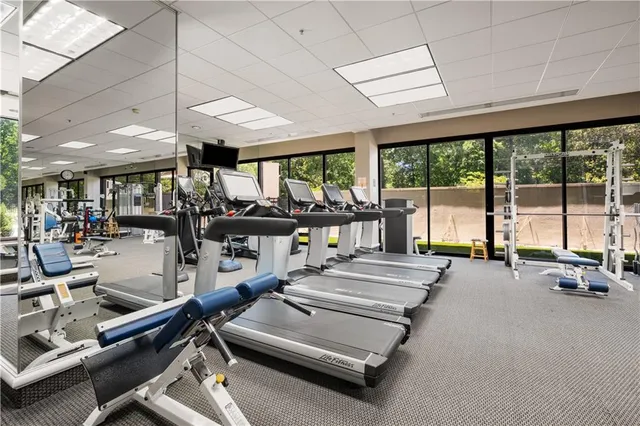 a room with gym equipment and large windows