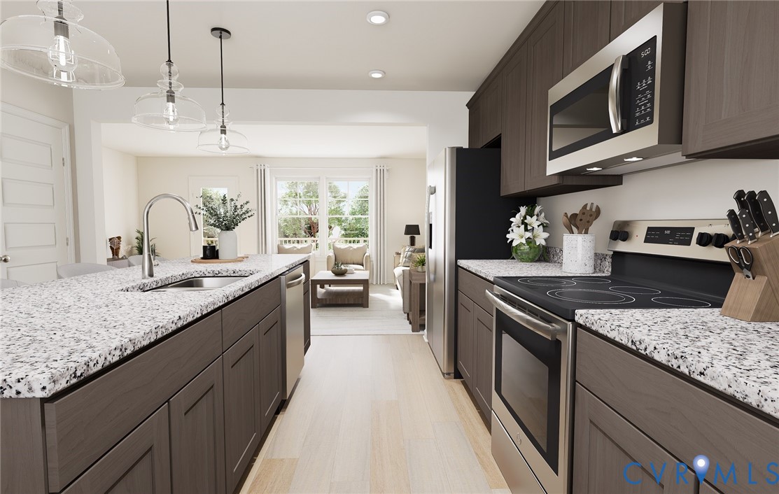 a kitchen with stainless steel appliances granite countertop a stove a sink and a microwave