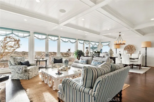 a view of a dining room and livingroom with furniture wooden floor a chandelier