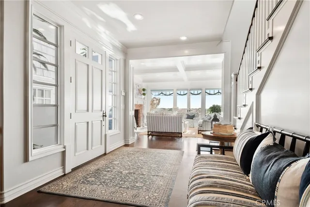 a living room with couches and a dining table with wooden floor