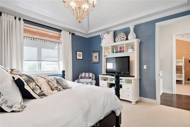 a dining room with wooden floor a chandelier a glass table and chairs