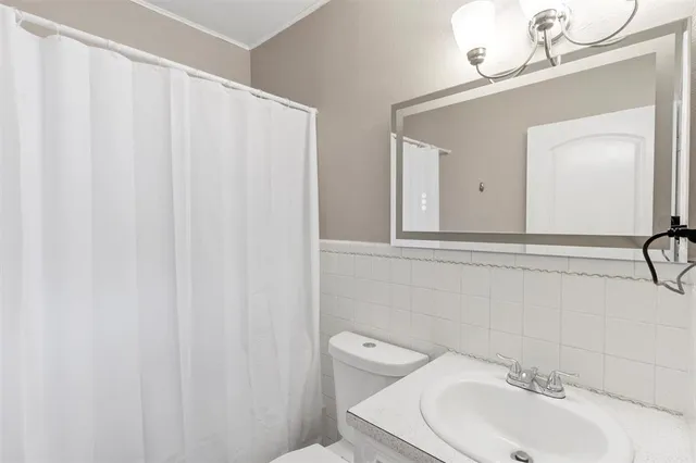 a bathroom with a sink a toilet and a mirror