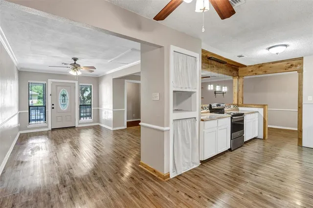 a kitchen with white cabinets and wooden floor
