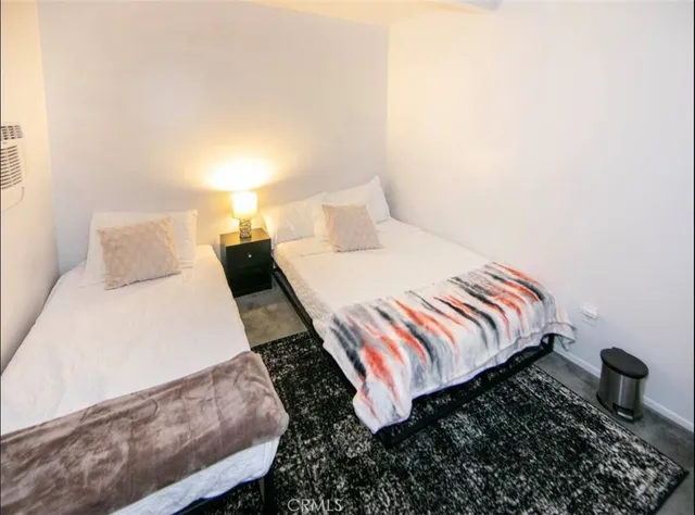 a bed sitting in a bedroom next to a lamp