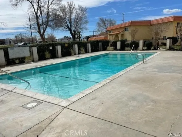 a view of a white house with a big yard and large trees