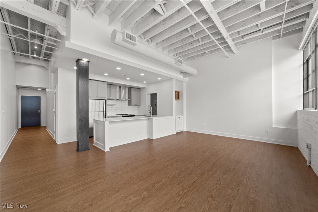 2048 Fulton Road, Unit 107 Cleveland, OH 44113 - Photo 23 of 37 View of kitchen and entry from living room with tall ceilings and exposed beams