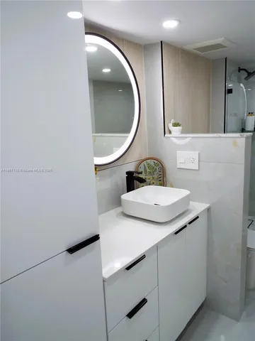 a bathroom with a granite countertop sink a toilet and shower