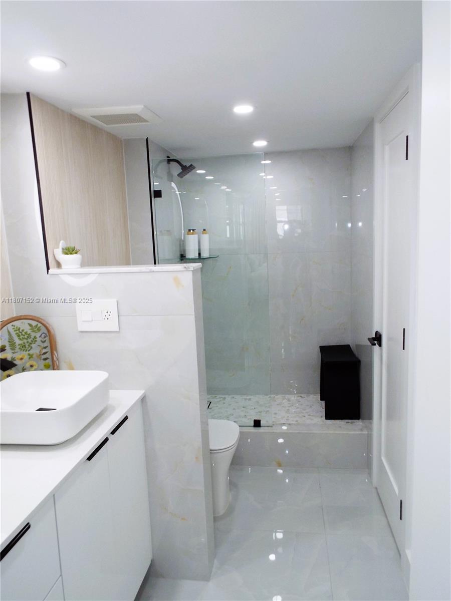 5701 Collins Avenue, Unit 1619 Miami Beach, FL 33140 - Photo 28 of 77 a bathroom with a sink a toilet and shower