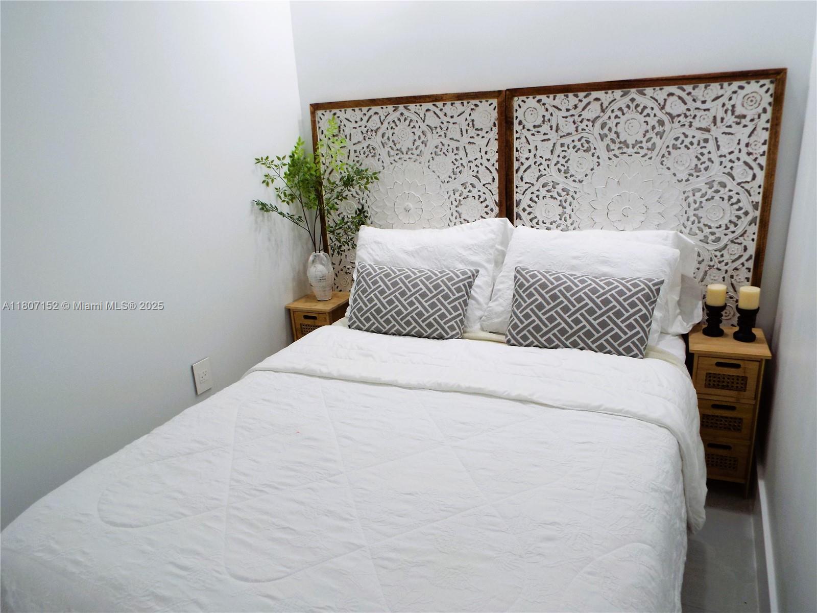 5701 Collins Avenue, Unit 1619 Miami Beach, FL 33140 - Photo 34 of 77 a bedroom with a large bed and a lamp on dresser