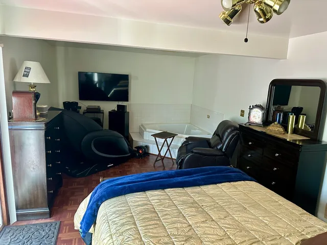 a bedroom with a bed and a flat screen tv