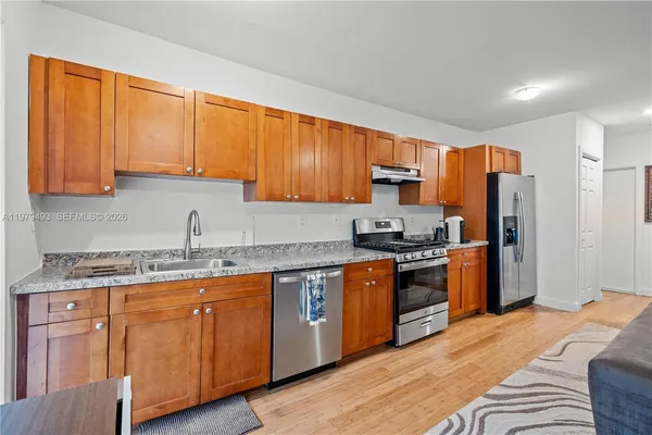 a kitchen with stainless steel appliances granite countertop a stove a sink dishwasher and a refrigerator