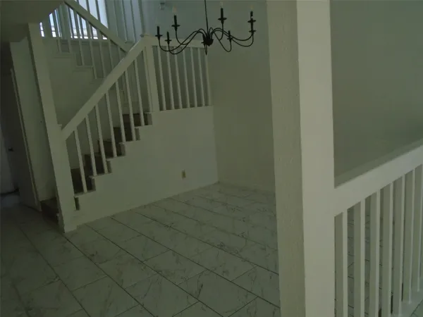 a view of staircase with railing and white walls