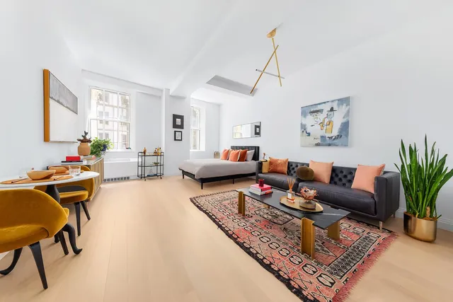 a living room with furniture a rug and a window