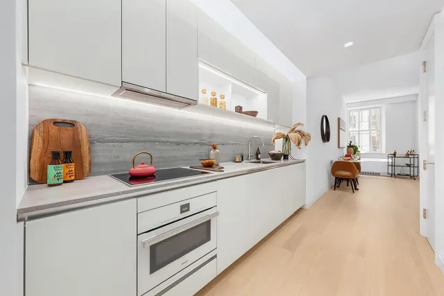 a kitchen with white cabinets and sink