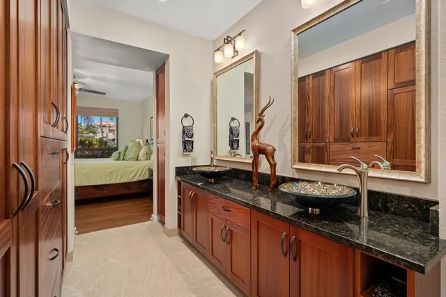 a en suite bathroom with granite countertop a sink and a mirror