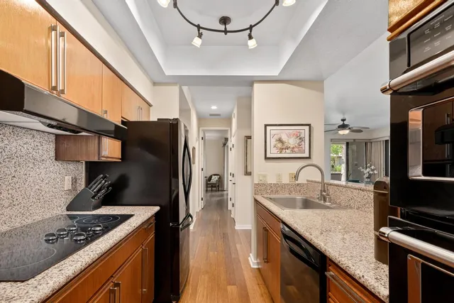 a kitchen with stainless steel appliances granite countertop a sink stove and refrigerator