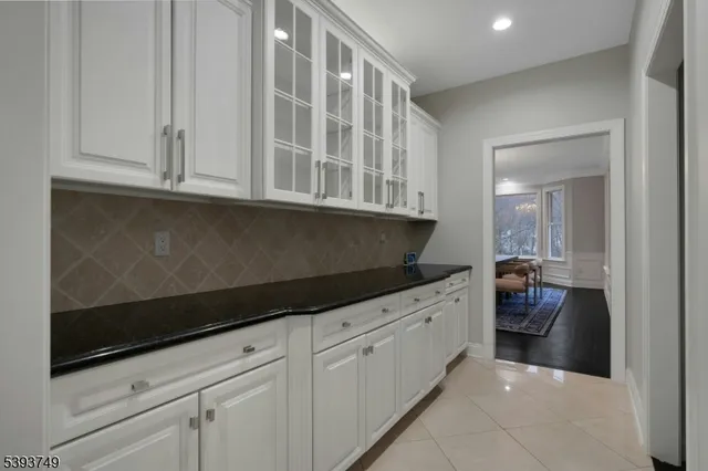 a kitchen with white cabinets and sink