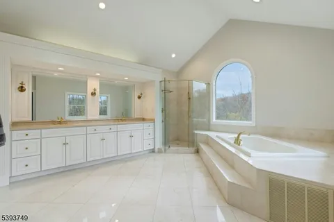 a spacious bathroom with a double vanity sink a large mirror and a bathtub