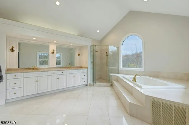 a spacious bathroom with a double vanity sink a large mirror and a bathtub