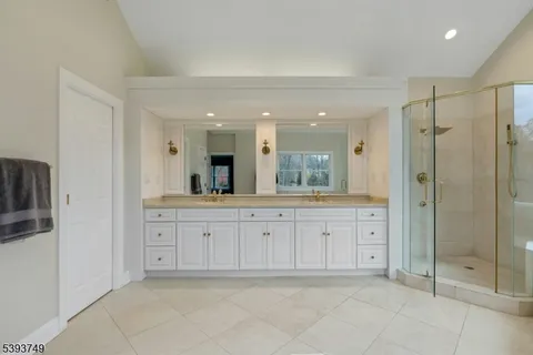 a spacious bathroom with a shower sink and mirror