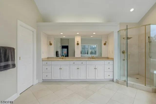 a spacious bathroom with a shower sink and mirror