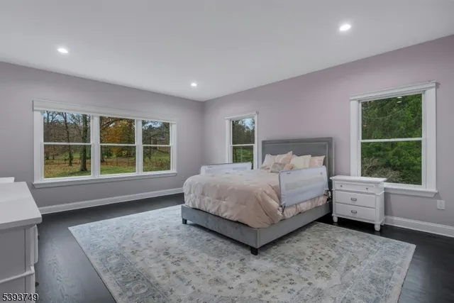 a bed sitting in a spacious bedroom next to a window