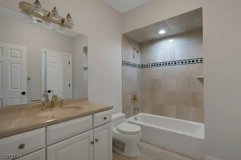 a bathroom with a granite countertop sink a toilet and bathtub