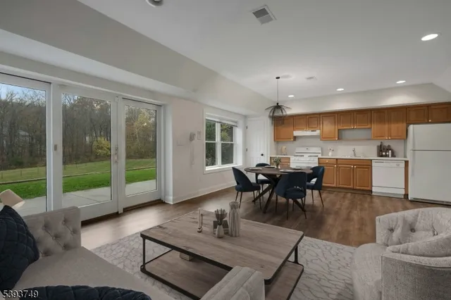 a living room with furniture and a view of kitchen