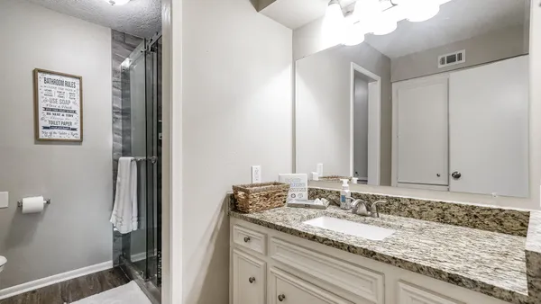 a bathroom with a granite countertop sink and a mirror