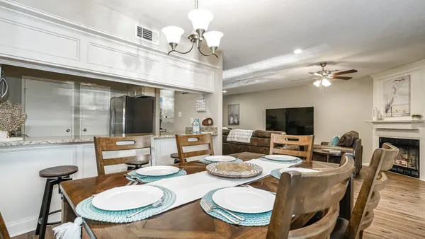 a view of a dining room with furniture a chandelier and wooden floor
