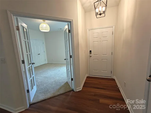 an empty room with wooden floor and entrance