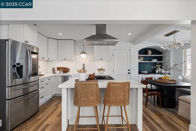 a kitchen with stainless steel appliances kitchen island granite countertop a dining table and chairs
