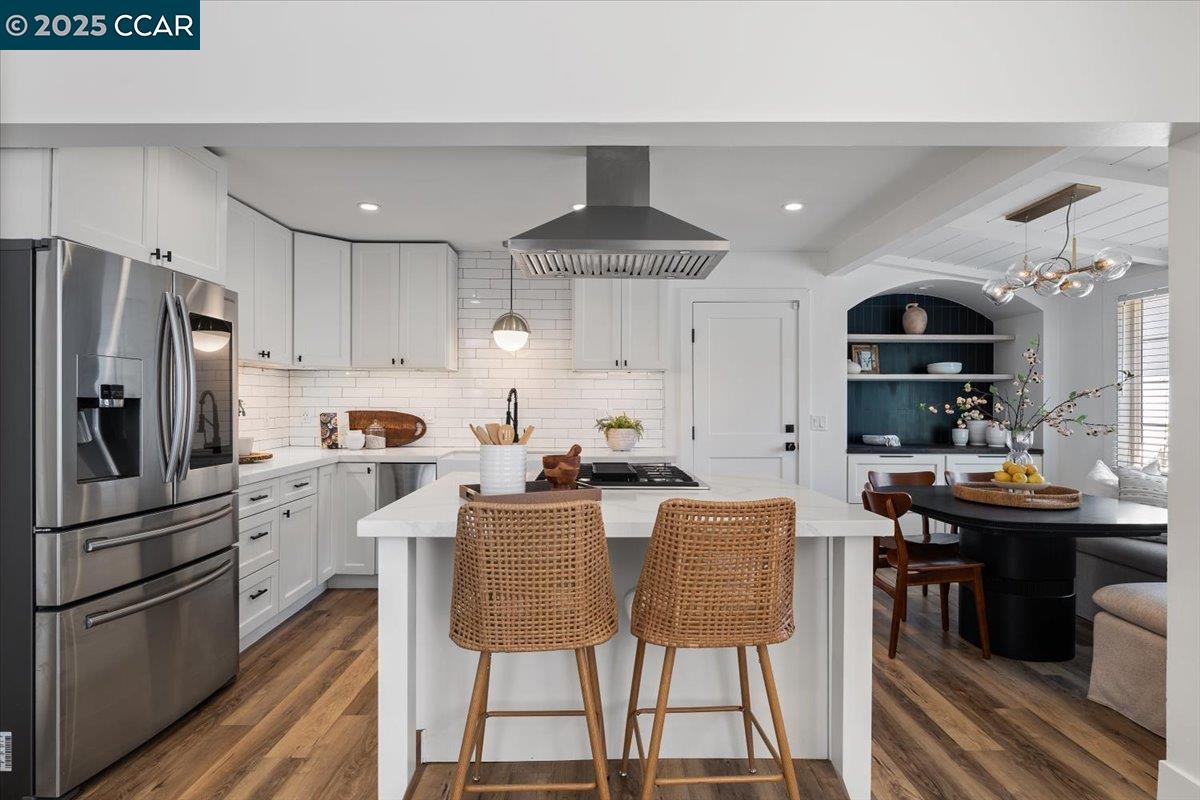 a kitchen with stainless steel appliances kitchen island granite countertop a dining table and chairs