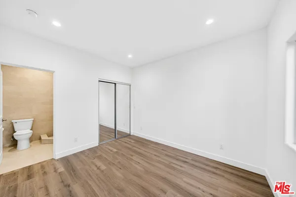 a view of a room with wooden floor and toilet
