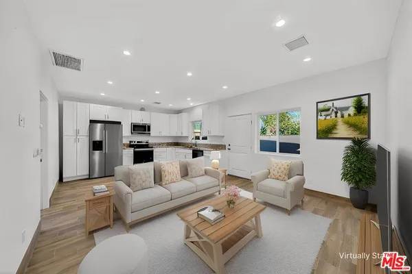 a living room with furniture kitchen and a table