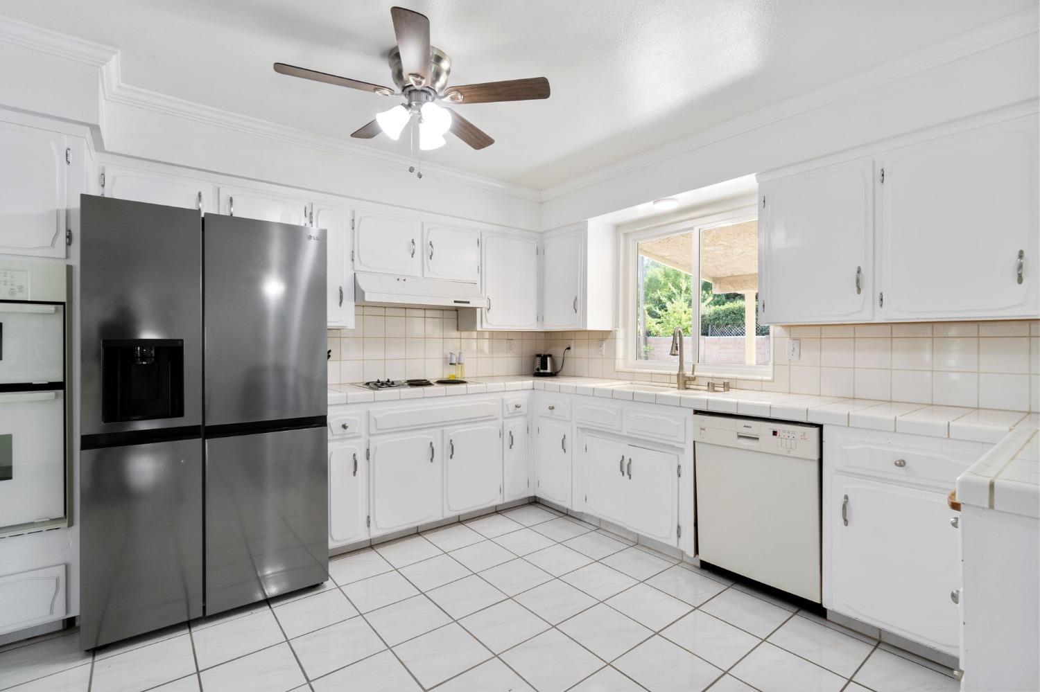 36264 Ave 12 Madera, CA 93636 - Photo 13 of 23 a kitchen with white cabinets stainless steel appliances and a window