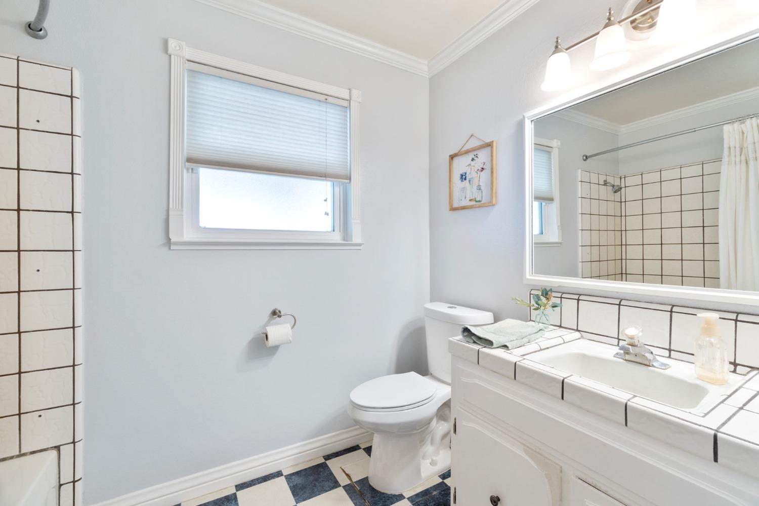 36264 Ave 12 Madera, CA 93636 - Photo 18 of 23 a bathroom with a toilet a sink a mirror and a window