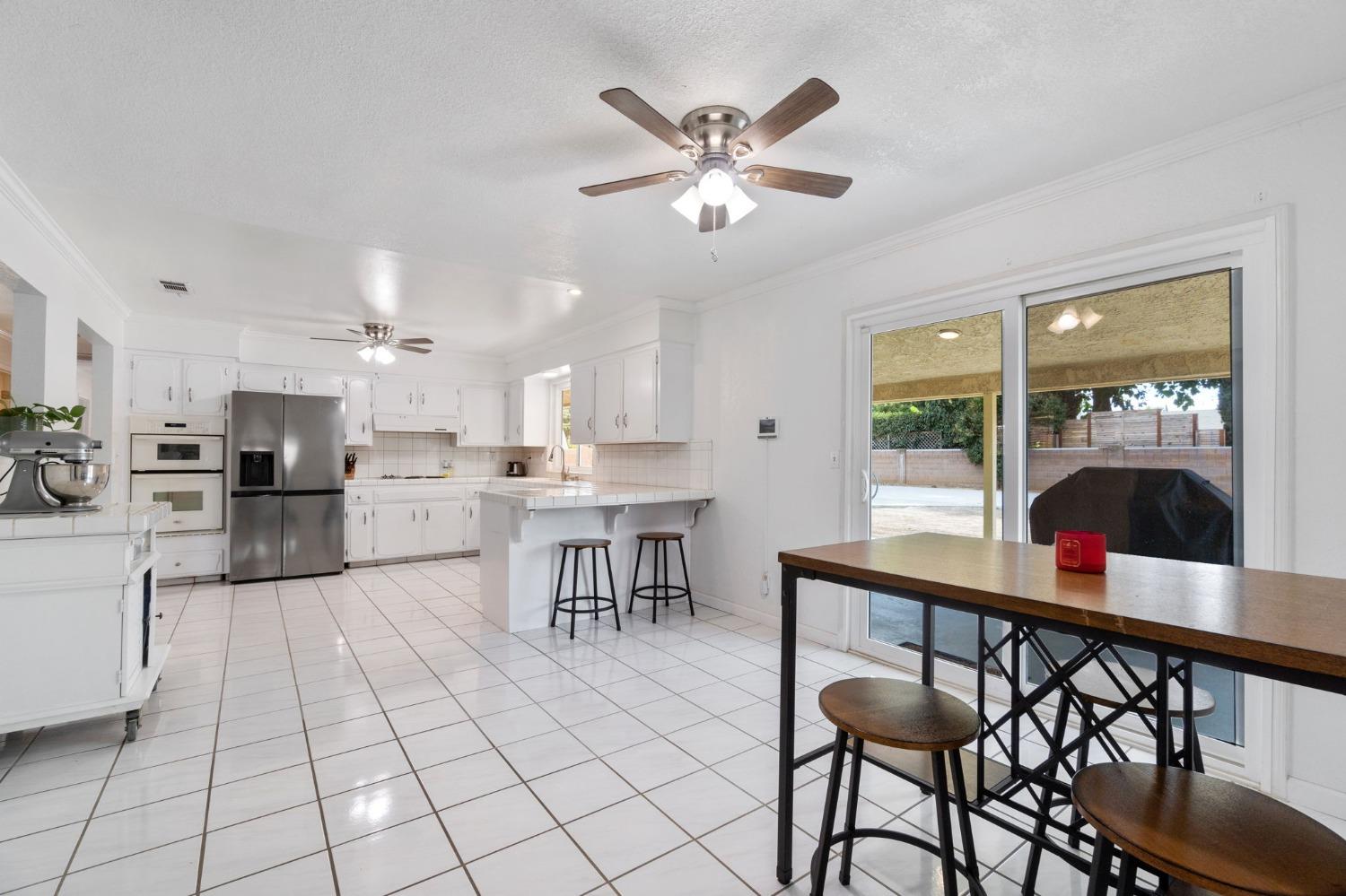 36264 Ave 12 Madera, CA 93636 - Photo 9 of 23 a open kitchen with stainless steel appliances kitchen island granite countertop a table and chairs in it