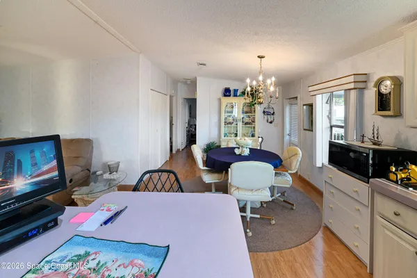 a kitchen with stainless steel appliances granite countertop a dining table chairs and a refrigerator