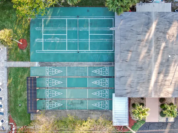 a view of a tennis ground with large trees